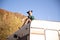 Young girl relaxing on the roof of a retro camper on the mountain