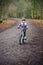 A young girl rides a bike along a country track towards the camera