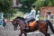 Young girl riding bay horse on show jumping training