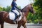 Young girl riding horse on equestrian competition