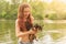 A young girl on the river with a chihuahua in her hands