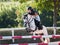 Young girl with roan pony upon hurdle on showjumping competition