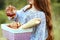 A young girl with a round bagel and holds a basket with homemade cakes on nature. Bakery and bread. Food advertising