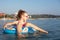 young girl on an rubber ring floats in the sea. happy childhood