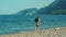 Young girl running along beach of sea. Teenager enjoying holidays on sea