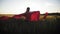 Young girl running with red tissue in green field. Happy cute girl playing in the wheat field on a warm summer day at