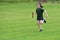 Young girl running relay race on grass running track outdoors