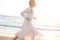 Young Girl Runs along the Sandy Beach of the Sea