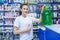 Young girl saleswoman approves of the right choice of non-freezing cleaning liquid for washing the windshield of a car