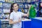 Young girl saleswoman approves of the right choice of non-freezing cleaning liquid for washing the windshield of a car