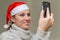 Young girl in santa claus hat talking on video communication with her friend