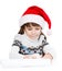 Young girl in Santa hat writes letter to Santa. isolated on whit