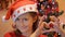 Young girl with Sants Claus Hat doing heart shape with hands with christmas tree as background