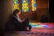 Young girl in a scarf sits on a floor in the mosque