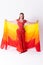 Young girl with shawl and in red dress performs oriental dance on white background