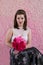 Young girl in sheer white top and vintage satin skirt sitting holding bouquet i