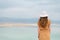 Young girl with shining blonde hair goes to seaside, Dead Sea beach. Banner. Travel, summer vacation, holiday, freedom concept.