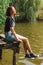 Young girl with short hair is sitting on a old wooden pierce