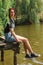 Young girl with short hair is sitting on a old wooden pierce