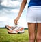 Young girl in shorts holding her sneakers