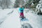 A young girl shoveling snow in a winter storm