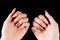 Young girl shows manicured hands on a black background. Pink coral nails