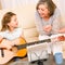 Young girl sing play guitar to grandmother