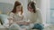 Young Girl Sit With Mom and Play Game on Smartphone