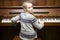 Young girl sits at brown upright piano