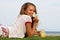 The young girl sits on a grass in the tropical country of the island Samui, the Girl drinks smoothie.