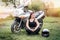 Young girl sits near sports motorcycle with helmet on the background of nature