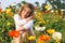 Young girl sitting around poppies in the evening in spring