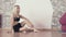 Young girl sitting on floor in dance studio. Pretty female resting after dance