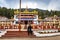 Young girl sitting in front of ancient buddhist colorful monastery at day