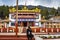 Young girl sitting in front of ancient buddhist colorful monastery at day