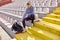 A young girl is sitting on the grandstand and concentrating for a training at the stadium by listening to a music. Sport,