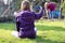 Young girl sitting on the grass and doing photo at the working w