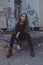 Young girl sitting and looking at the background of the ruined Soviet