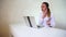 Young girl sitting near laptop and talking about present for brother.