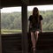 Young girl sitting on the railing of a wooden gazebo