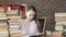 Young girl is sitting in room home table and reading book. student studies home