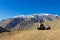 Young girl sitting staring at the sun by Andes snowy mountain range