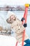 Young girl sitting on swing on bank of winter pond