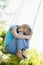 Young girl sitting on swing smiling