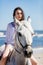 Young girl sitting on a white horse on the seashore