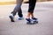 Young girl skateboarding with her dad running at park outdoor i