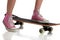 Young girl skateboarding with pink sneakers