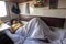 A young girl sleeps on a lower bunk in a reserved seat of a train car