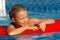 Young Girl Smiles on Float Toy in Pool