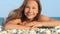 Young girl smiling on sea beach. Portrait of smiling girl lying on pebble beach